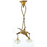 A gilt metal ceiling light modelled as Eros suspended by ropes carrying opaque floral moulded