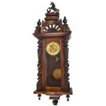 A late 19th century walnut cased spring driven Vienna wall clock, the chapter ring set with Roman
