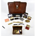 A cow hide leather briefcase containing various collectors' items including cufflinks, wristwatch,