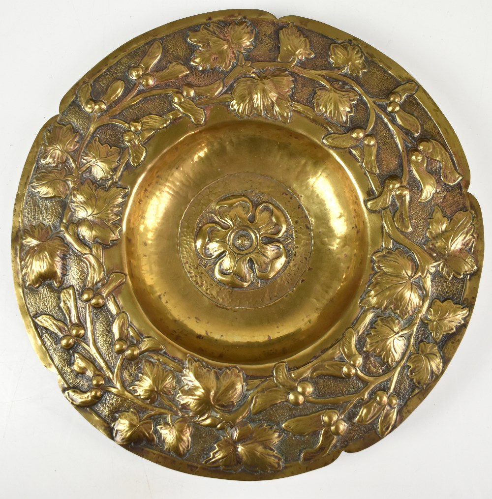 An Arts & Crafts brass bowl with repoussé decoration of a central Tudor Rose and further floral