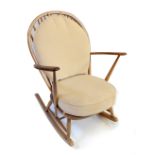 ERCOL; a light elm spindle back rocking chair.Additional InformationHeavy wear, splitting to the top