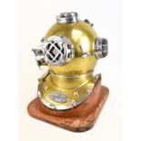 A reproduction diver’s helmet mounted on a wooden plinth, height 52cm.Additional InformationSome