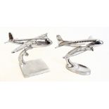 Two modern models of polished aluminium aircraft on swept bases, lengths approx 38cm each.