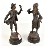 A pair of late 19th/early 20th century French bronzed spelter figures comprising gentleman holding