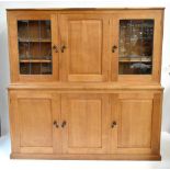 DEREK 'LIZARDMAN' SLATER; a light oak bookcase, the upper section with central panelled cupboard