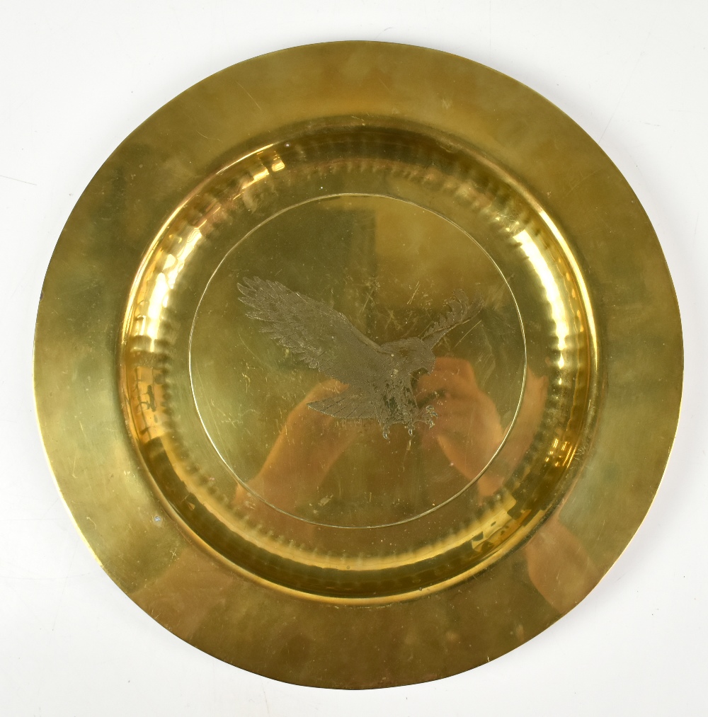 An early/mid-20th century brass charger with engraved central decoration depicting an eagle in