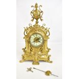 A late 19th century French gilt metal Rococo-style eight day mantel clock, the pierced case with urn