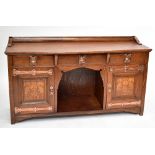 SHAPLAND & PETTER; an Arts and Crafts inlaid oak serpentine fronted sideboard, with three central