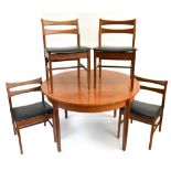 A mid-century teak dining suite comprising circular extending dining table with one extra leaf and