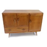 ERCOL; a medium elm sideboard with three panelled doors and single base drawer, raised on column