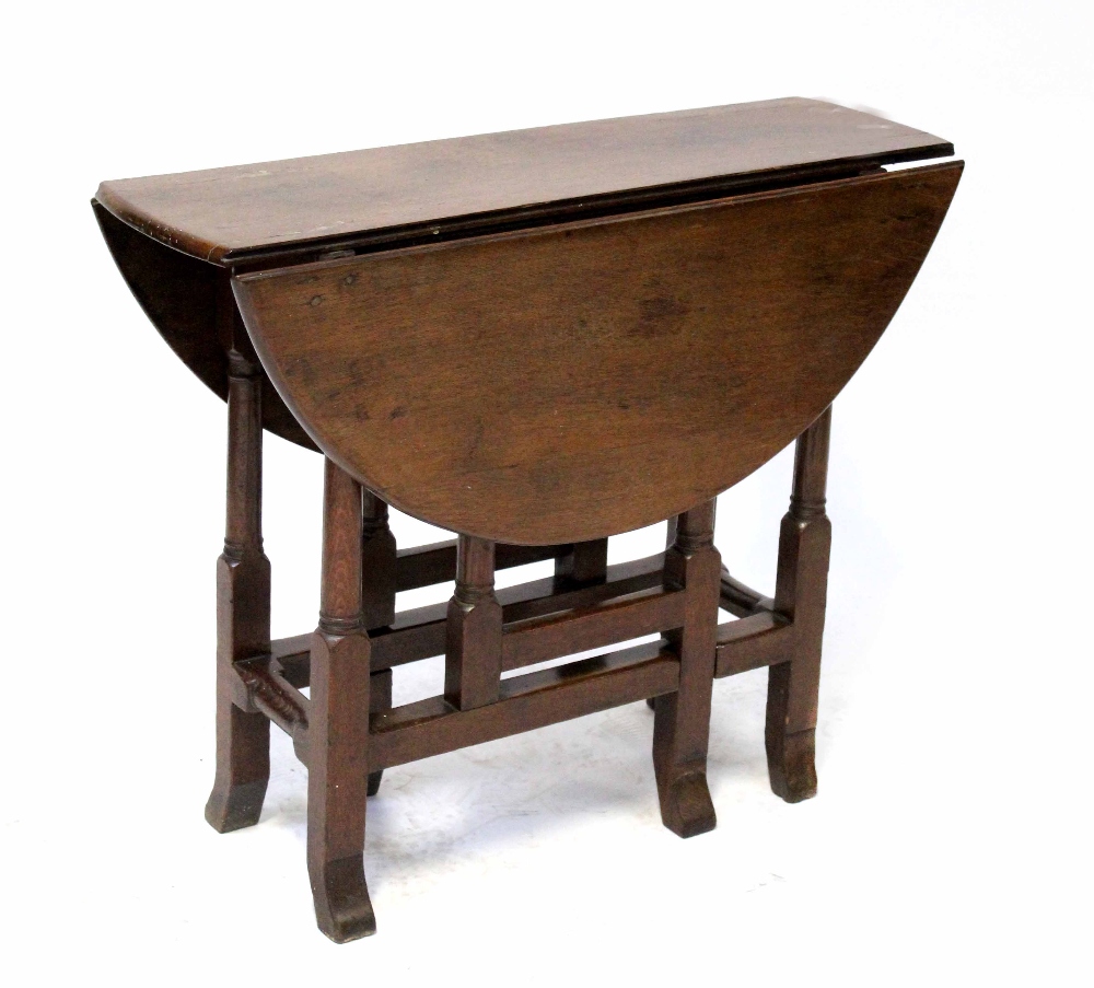 A George III oak dropleaf gateleg D-end table on turned and block legs with stretchers,