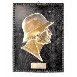 A German award plaque depicting the head of a German soldier wearing steel helmet,