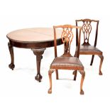 An early 20th century Georgian-style mahogany dining suite comprising a wind-out extending oval