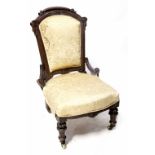 A 19th century walnut bedroom/nursing chair with carved top rail, sides and short arms,
