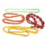 A green jade bead necklace and three amber-style necklaces (4).