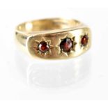 A gentlemen's 9ct gold gypsy ring set with three garnets, stamped 375, approx 6.7g.