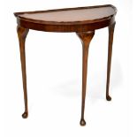 A Reprodux mahogany demi-lune console table with piecrust rim and raised on cabriole legs to pad
