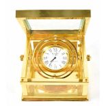 A boxed Sewills brass-cased gimbal mantel clock, the dial set with Roman numerals, 8 x 8cm.