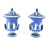 A pair of Wedgwood jasper ware covered twin-handled vases modelled as urns, in dark blue,