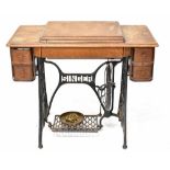 A vintage oak-cased Singer treadle sewing machine.