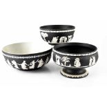 Three Wedgwood black jasper ware bowls with Classical figures in relief within borders of oak
