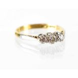 An 18ct gold three-stone diamond ring, the three platinum claw-set small diamonds approx 0.