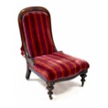 A Victorian mahogany-framed nursing chair to front carved supports and castors.
