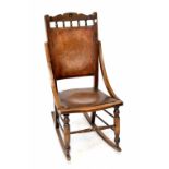 An Edwardian mahogany-framed rocking chair with floral decoration to seat and back.