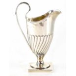A 19th century hallmarked silver cream jug of helmet form with half fluted body, on square base,