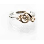 An 18ct white gold three-stone diamond ring, three small platinum claw-set brilliant diamonds,