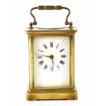 A brass-cased carriage clock, the enamelled dial set with Roman numerals, in corniche case,