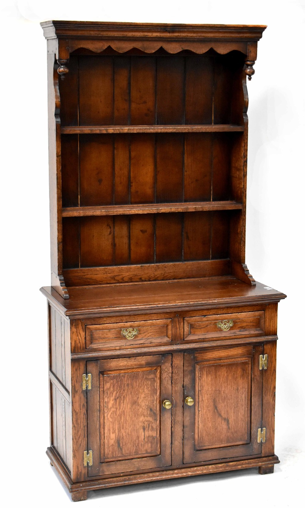 A reproduction oak dresser with enclosed plate rack on a base of two drawers and a pair of cupboard