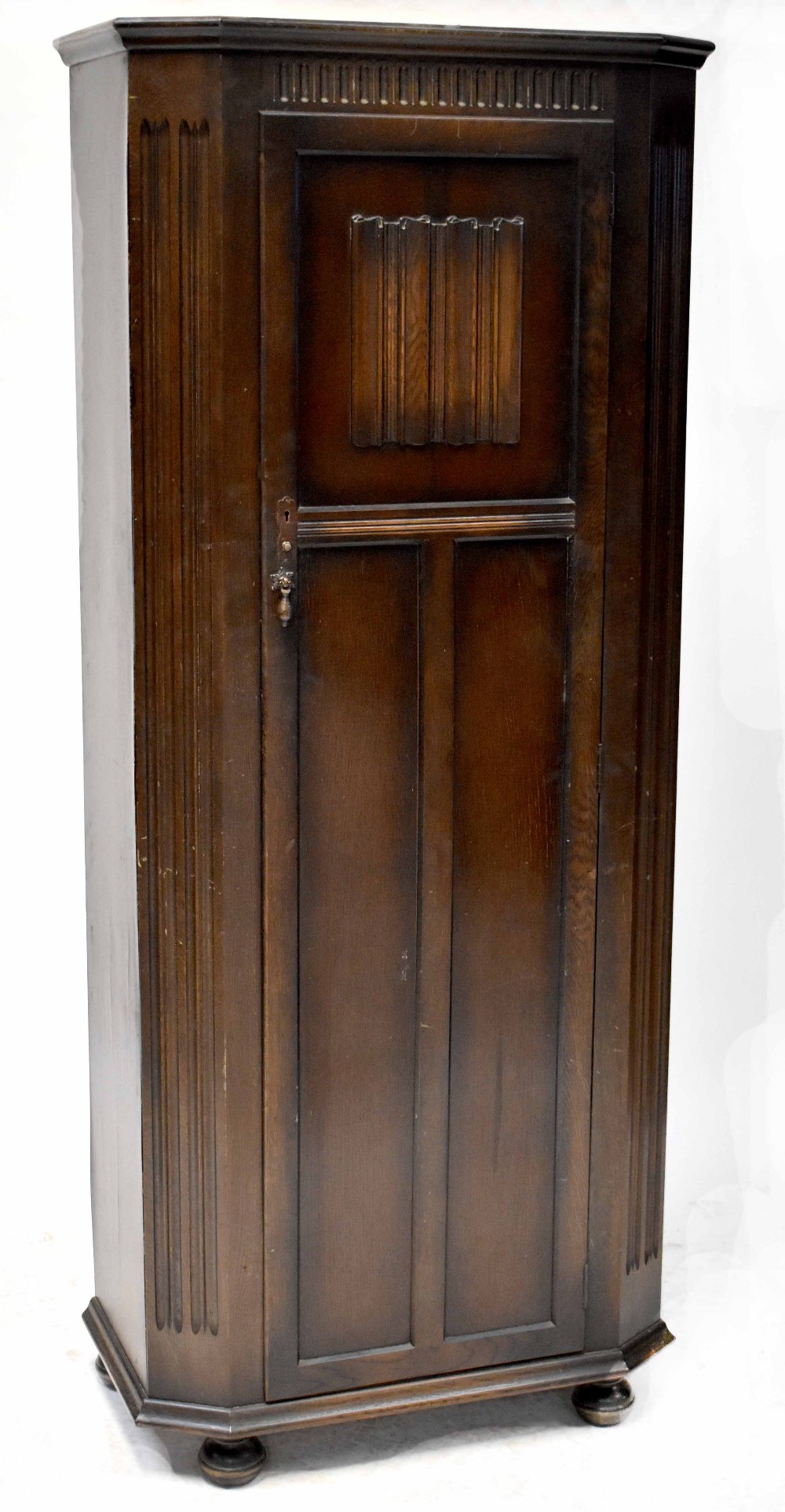 A 1930s priory-style oak hall robe with carved and linenfold decoration, height 189cm, width 79cm,