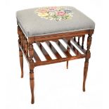 An Edwardian beech piano stool with rectangular tapestry top, with slatted under shelf,