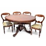 A Victorian mahogany oval tilt-top dining table on bulbous carved supports and tripod base and four