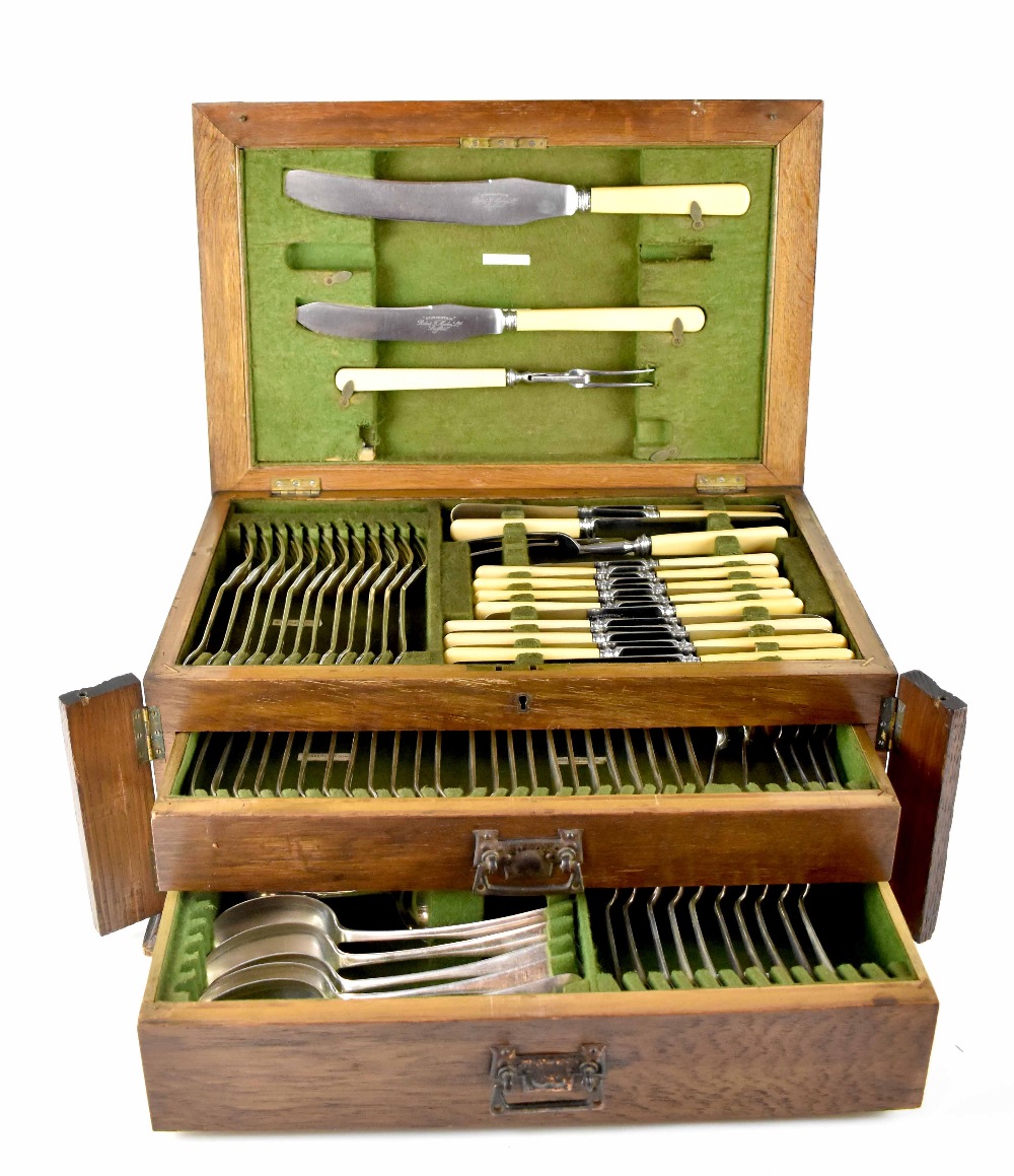 A c1921 oak-cased two-drawer twelve setting canteen of cutlery,