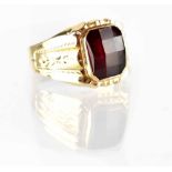 A gentlemen's yellow metal dress ring set with facet-cut ruby within a band with engraved foliate