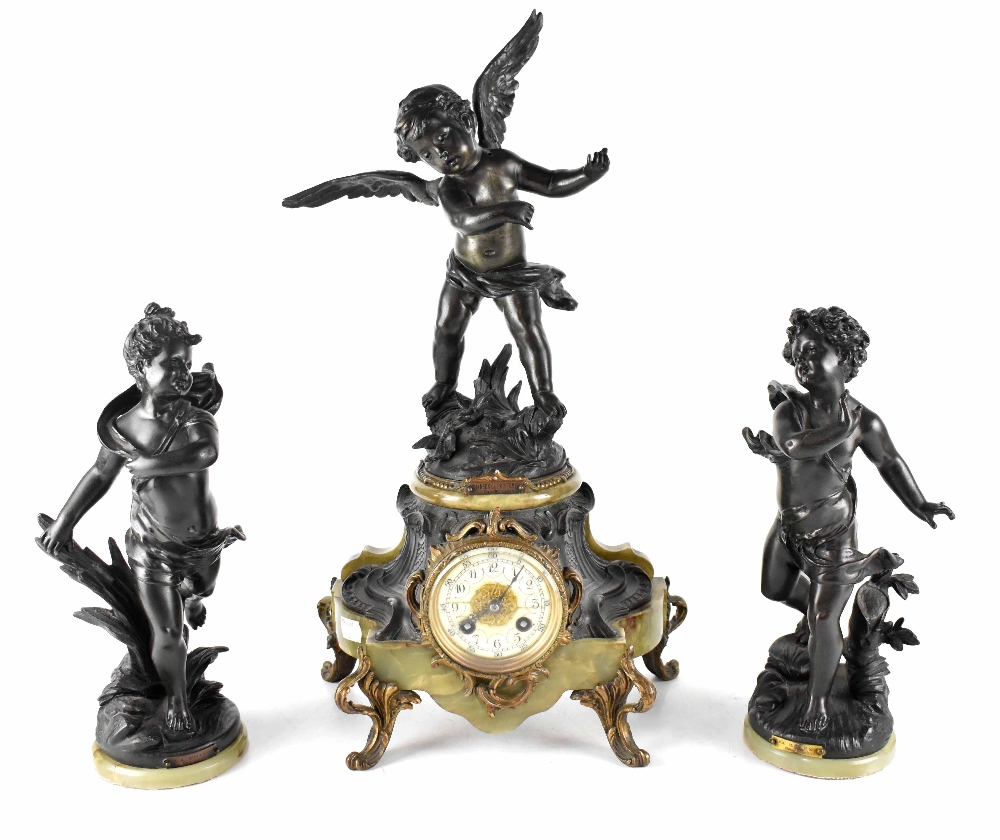 A French onyx and spelter clock garniture, the clock with ivorine dial set with Arabic numerals,