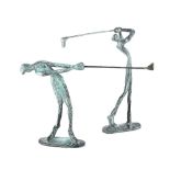 A pair of bronze figures of golfers in mid-swing,