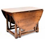 A reproduction oak gateleg supper table with oval top and on turned legs to block feet and