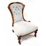 A Victorian inlaid walnut nursing chair upholstered in light blue, on turned tapering legs.