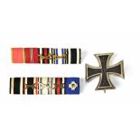 A German WWI First Class Iron Cross and two five-bar ribbon bars.