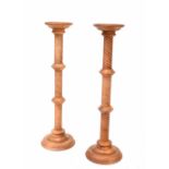 A pair of reproduction stained wood torchère stands with wrythen reeded columns and on stepped