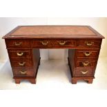 A reproduction mahogany twin pedestal desk, the top with inset gilt tooled tan leather writing