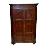 A George III mahogany corner cupboard with marquetry detail to frieze above twin arcaded and