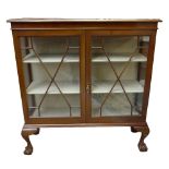 A 1930s mahogany display cabinet with twin astragal glazed doors, raised on squat cabriole legs to