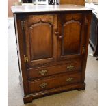 An oak TV cabinet with twin doors above two long drawers on bracket feet, height 102cm, width 81.