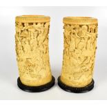 A pair of 19th century Chinese Canton carved ivory tusk vases decorated with stylised figures in