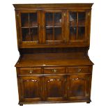 A reproduction oak dresser, the upper section with three glazed doors above three drawers and