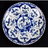 A Chinese Kangxi period porcelain charger painted in underglaze blue with floral decoration and with